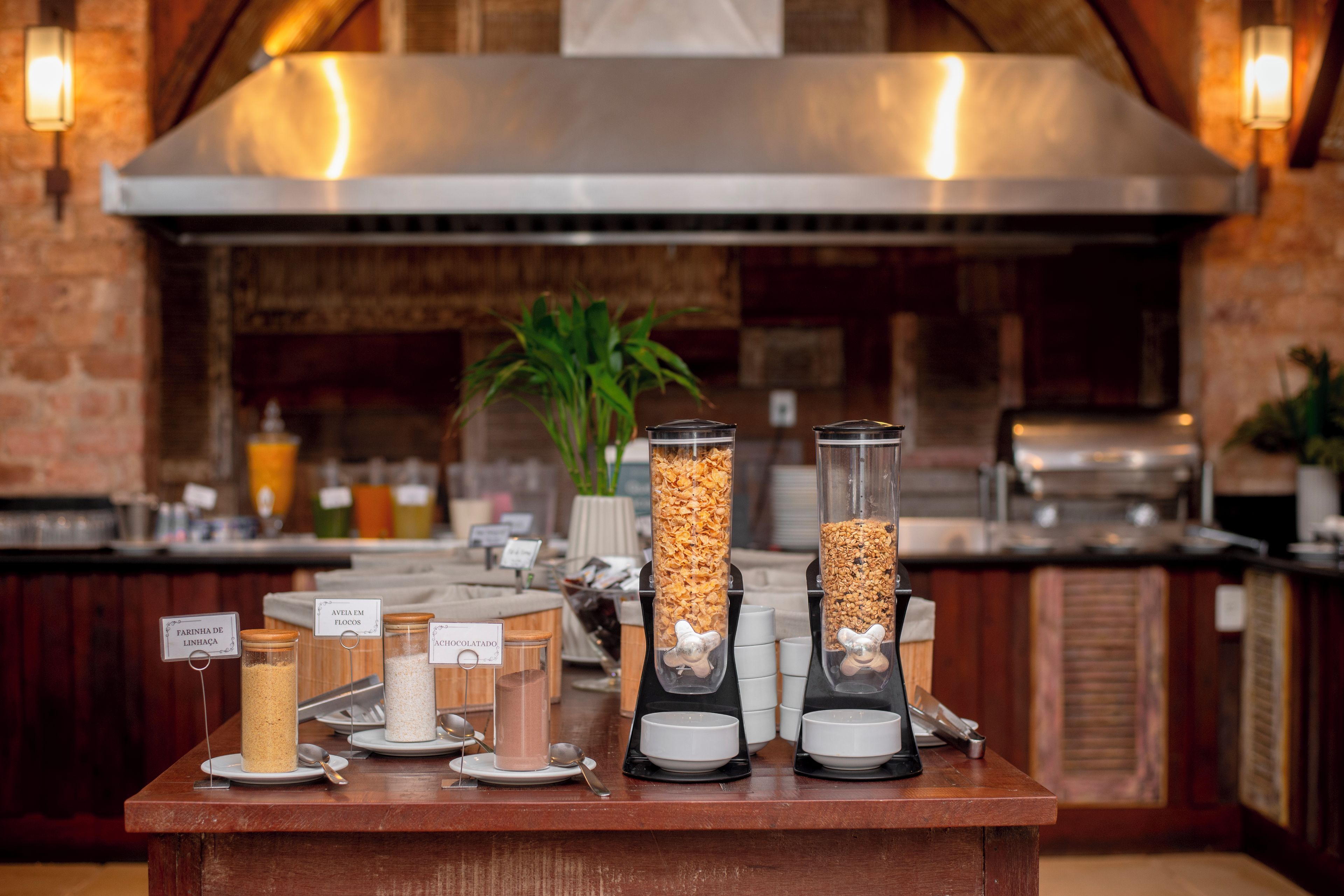 A breakfast bar with various food items and containers, including jars of granola and chocolate.