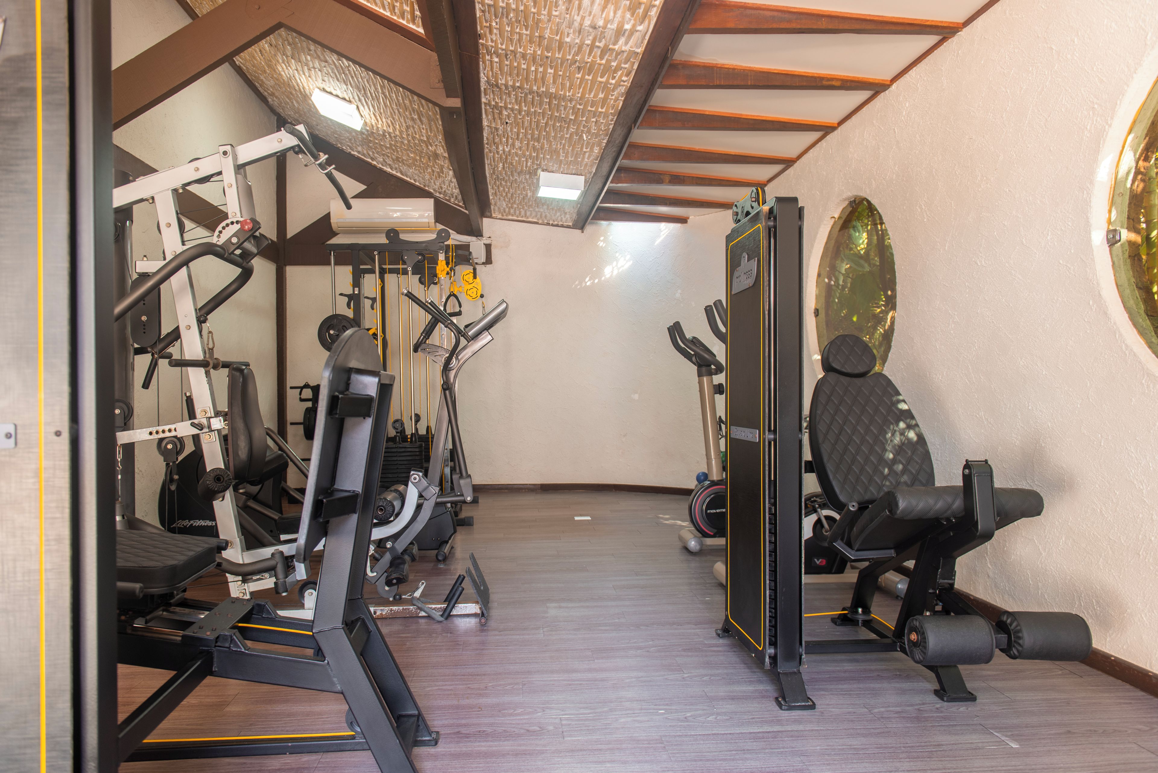 A gym with various exercise equipment, including a treadmill, weight machines, and a stationary bike.