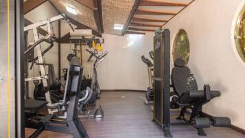A gym with various exercise equipment, including a treadmill, weight machines, and a stationary bike.