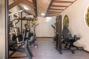 Un gimnasio con diversos equipos de ejercicio, como cintas de correr, máquinas de pesas y bicicletas estáticas.