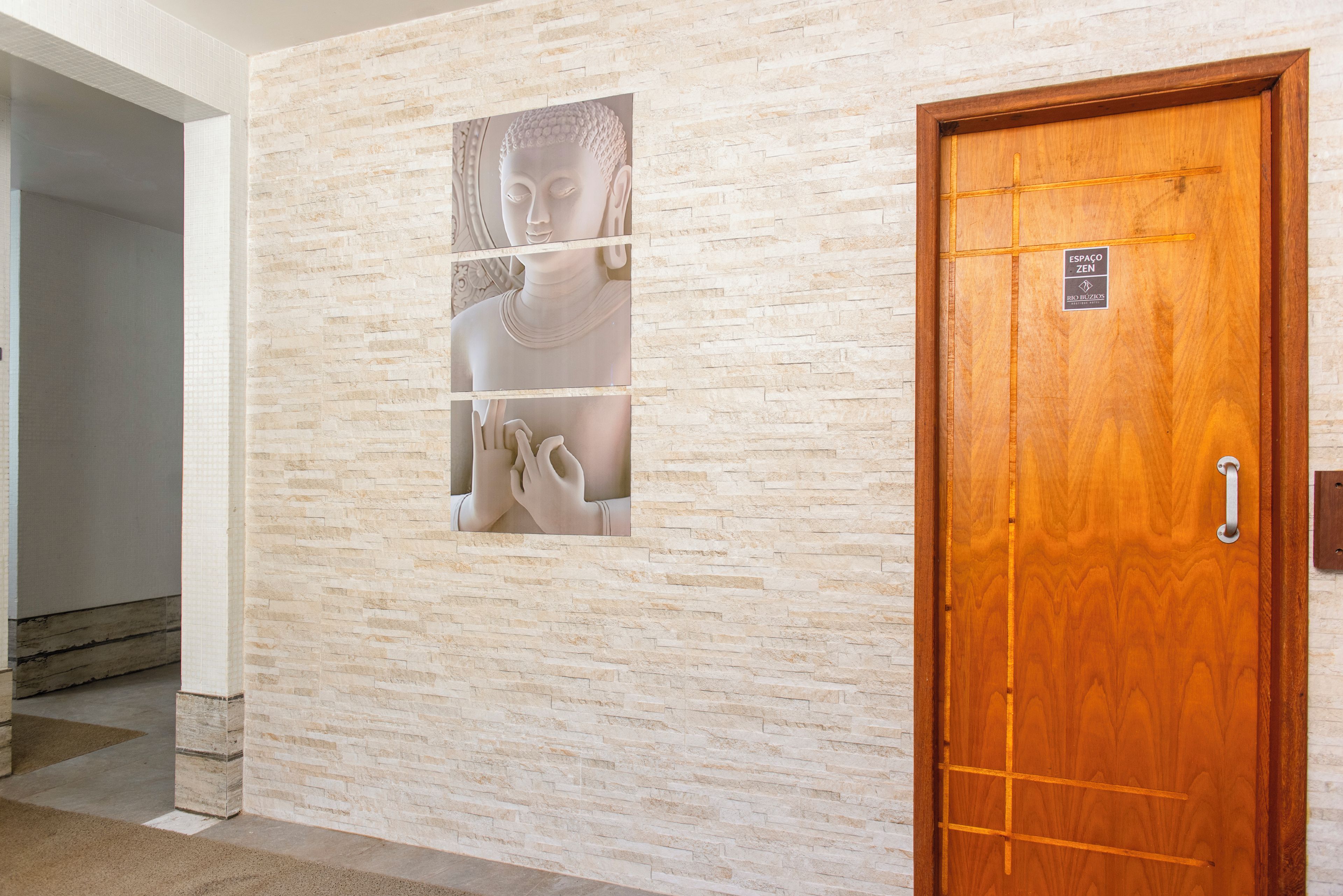 Un pasillo con pared de piedra y puerta de madera con un letrero.