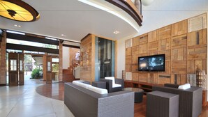 A modern lobby with a large seating area, a staircase, and a TV on the wall. - Rio Buzios Boutique Hotel (Búzios)