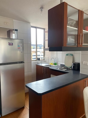 Refrigerador, microondas, tetera eléctrica y utensilios de cocina