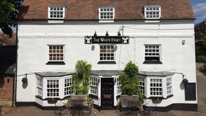 A white building with a black sign reading "The White Hart". - The White Hart (Newport Pagnell)