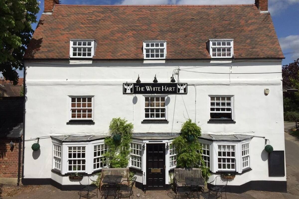 A white building with a black sign reading "The White Hart".