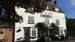 A white building with a sign reading "The White Hart". - The White Hart (Newport Pagnell)