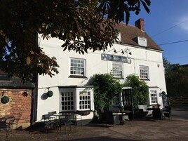 Um edifício branco com uma placa que diz 'The White Hart'.