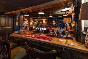 A bar area with multiple beer taps, a 'REAL ALE' sign, and a 'LONDON PRIDE' tap. - The Union Inn (Cowes)