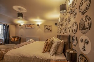 Una camera da letto con un letto grande, una sedia e un muro decorato con diversi ritratti circolari.