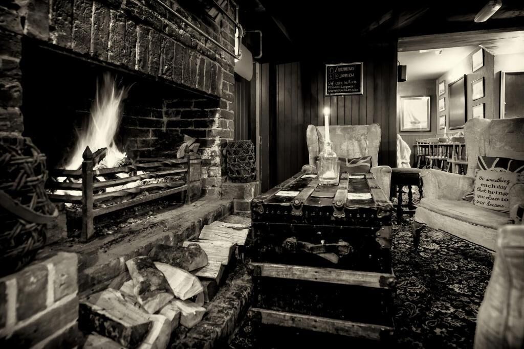 A cozy room with a fireplace, wooden furniture, and a sign with a message.