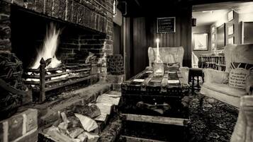 A cozy room with a fireplace, wooden furniture, and a sign with a message.
