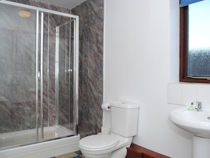 A bathroom with a glass-enclosed shower, a white toilet, and a sink with a mirror above it. - The Marsham Arms Inn (Norwich)