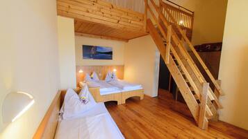 Ein Schlafzimmer mit zwei Betten, einer Holztreppe und einem gerahmten Bild an der Wand.
