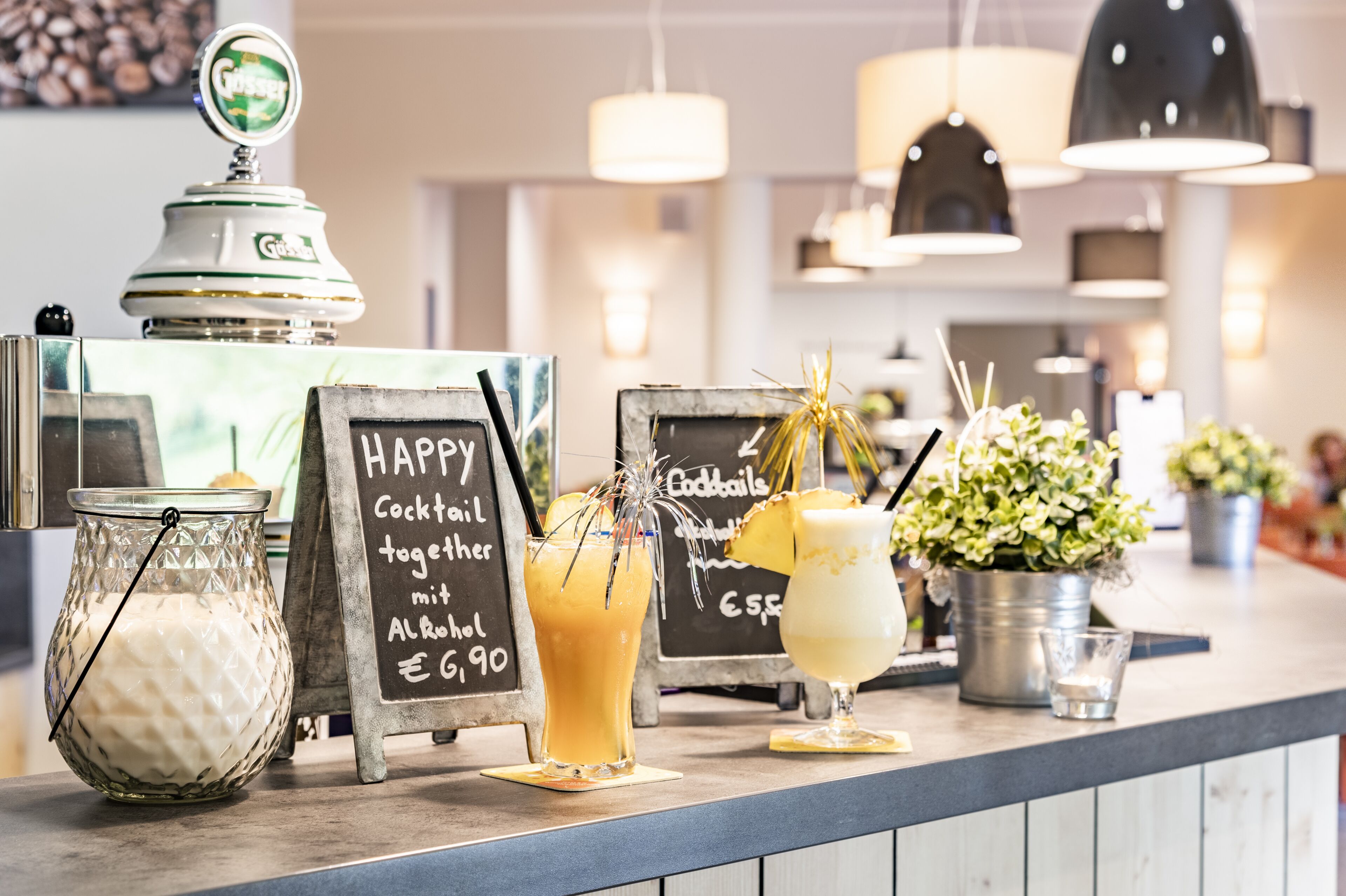 A bar area with a chalkboard menu, a jar of milk, and a cocktail with a pineapple garnish.