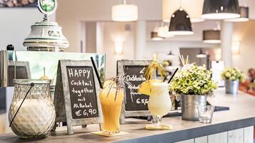 A bar area with a chalkboard menu, a jar of milk, and a cocktail with a pineapple garnish.
