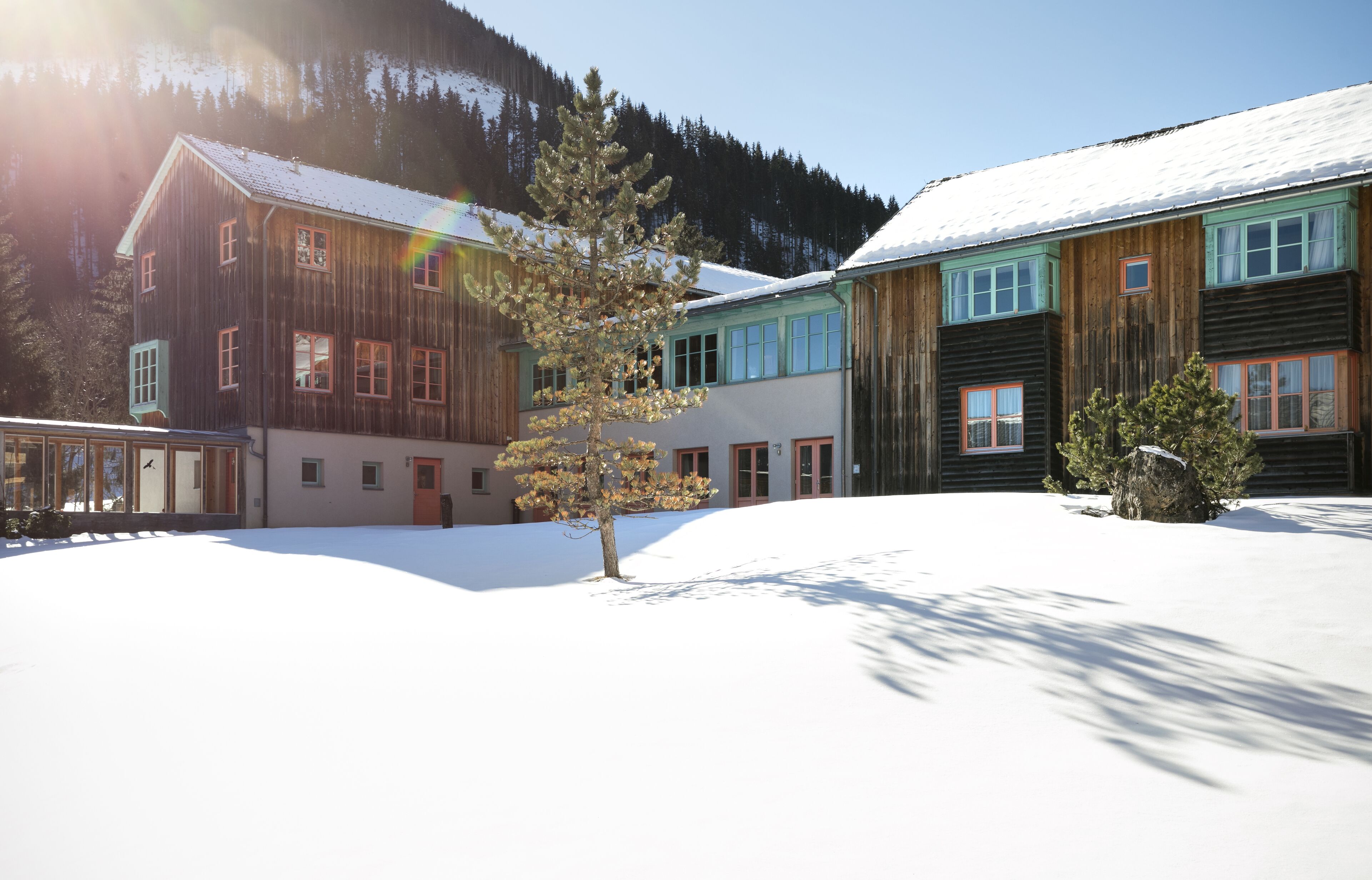 Un edificio de madera con varias ventanas y un suelo cubierto de nieve.