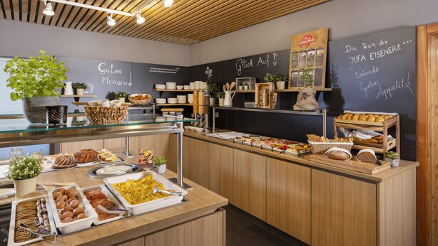 A buffet area with various food items and a chalkboard menu.