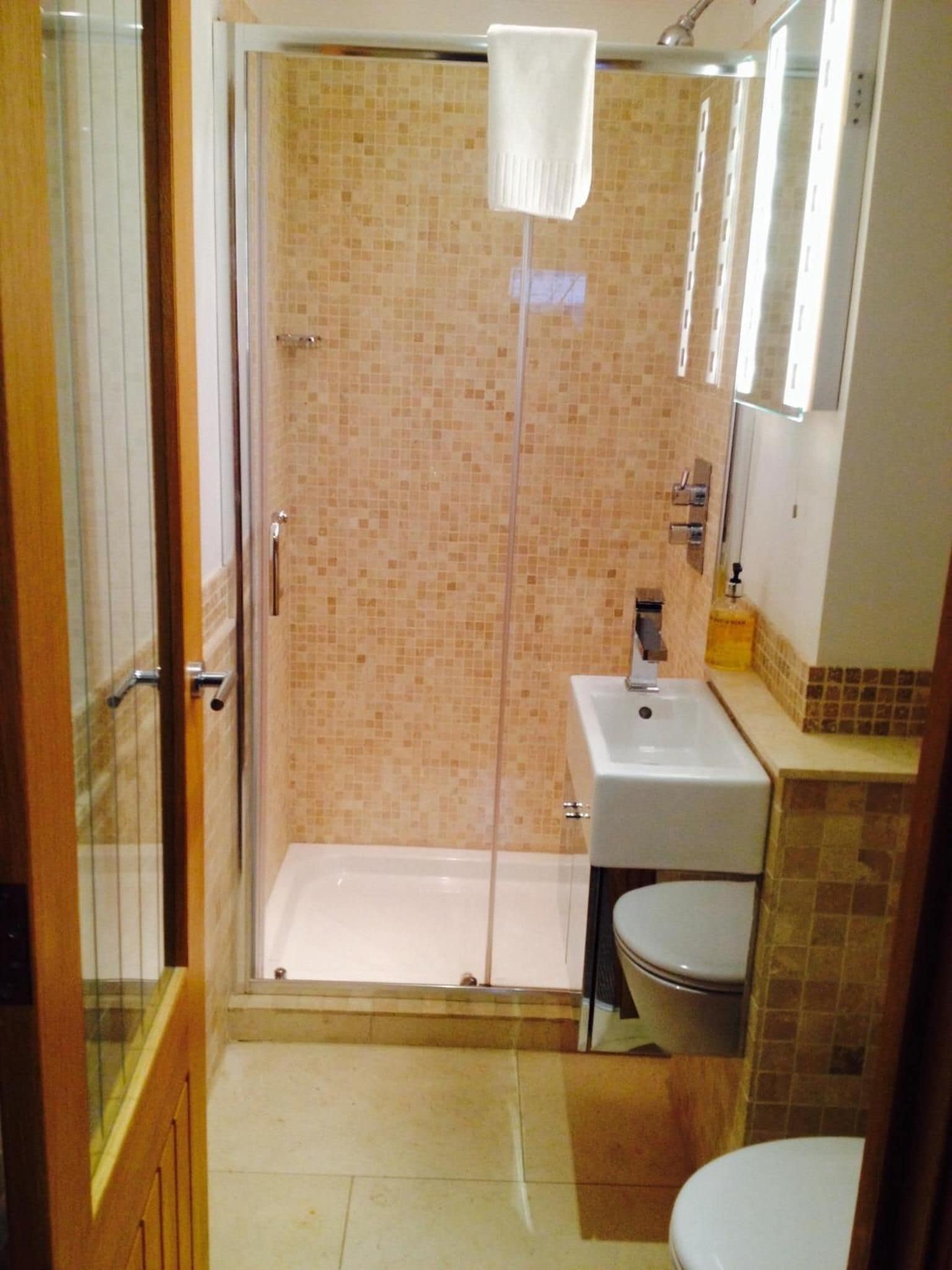 Ein Badezimmer mit einer Duschkabine, einem Waschbecken und einer Toilette.