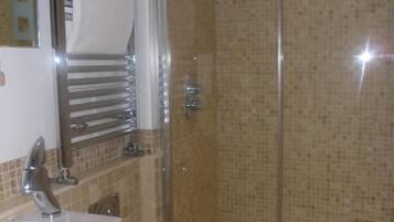 Un baño con inodoro, lavamanos y zona de ducha.