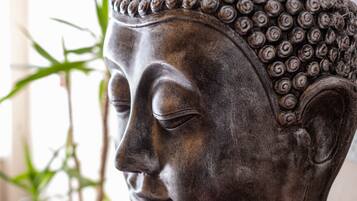 A close-up of a Buddha statue with a detailed head and a textured surface.