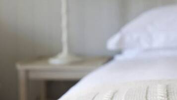 Una camera da letto con un letto, un comodino e una lampada.
