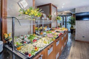 A buffet with various food items and a glass display case. - Hotel Momento - Special Class (Istanbul)