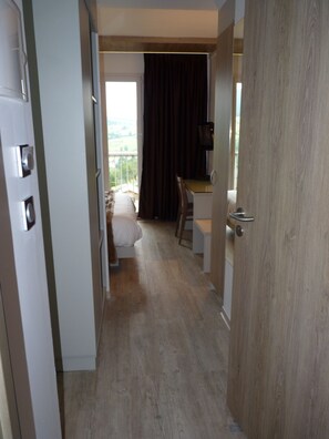Une chambre d’hôtel avec un lit, un bureau et une vue sur l’extérieur.