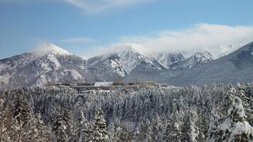 Un paysage montagneux enneigé, avec un bâtiment au premier plan.