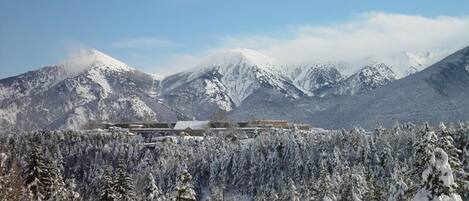 A snow-covered mountain landscape with a building in the foreground.