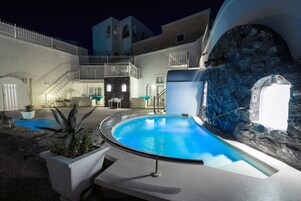 Un área de piscina con un muro de piedra y una escalera que sube a niveles superiores.