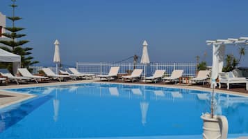 Een seizoensgebonden buitenzwembad, parasols voor strand/zwembad