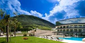 Relax by the pool surrounded by lush greenery and a majestic mountain view.