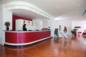 Welcome to our reception area, featuring a curved desk, potted plants, and modern furnishings.
