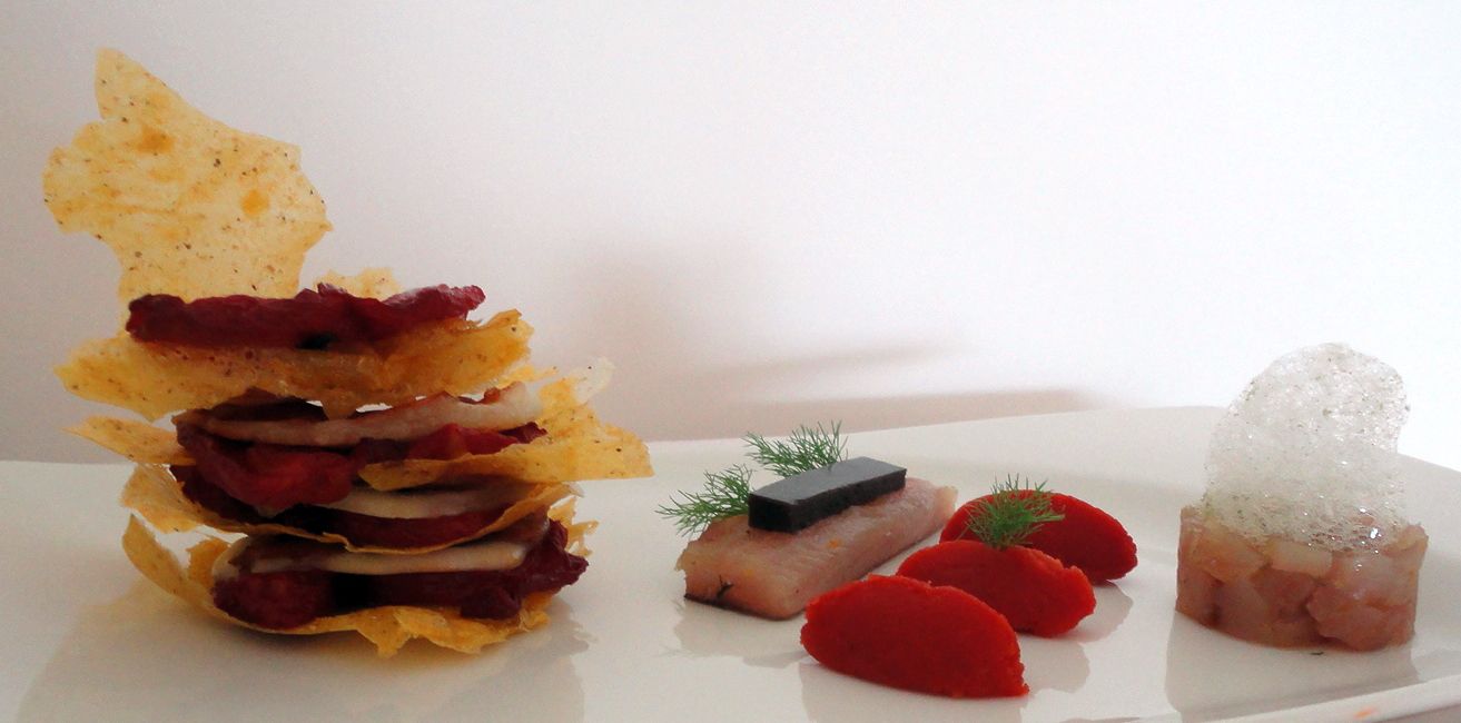 Un plato con diferentes alimentos, incluyendo papas fritas, una porción de carne, un trozo de pescado y algunas guarniciones.
