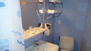 Une salle de bain équipée d’un lavabo, de toilettes et d’un porte-serviettes.