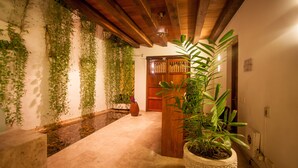 A hallway with a wooden ceiling, a large potted plant, and hanging vines. - Casa Claver Loft Boutique Hotel (Cartagena)
