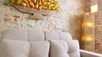 A beige sofa in a room with a textured wall and a fruit arrangement.