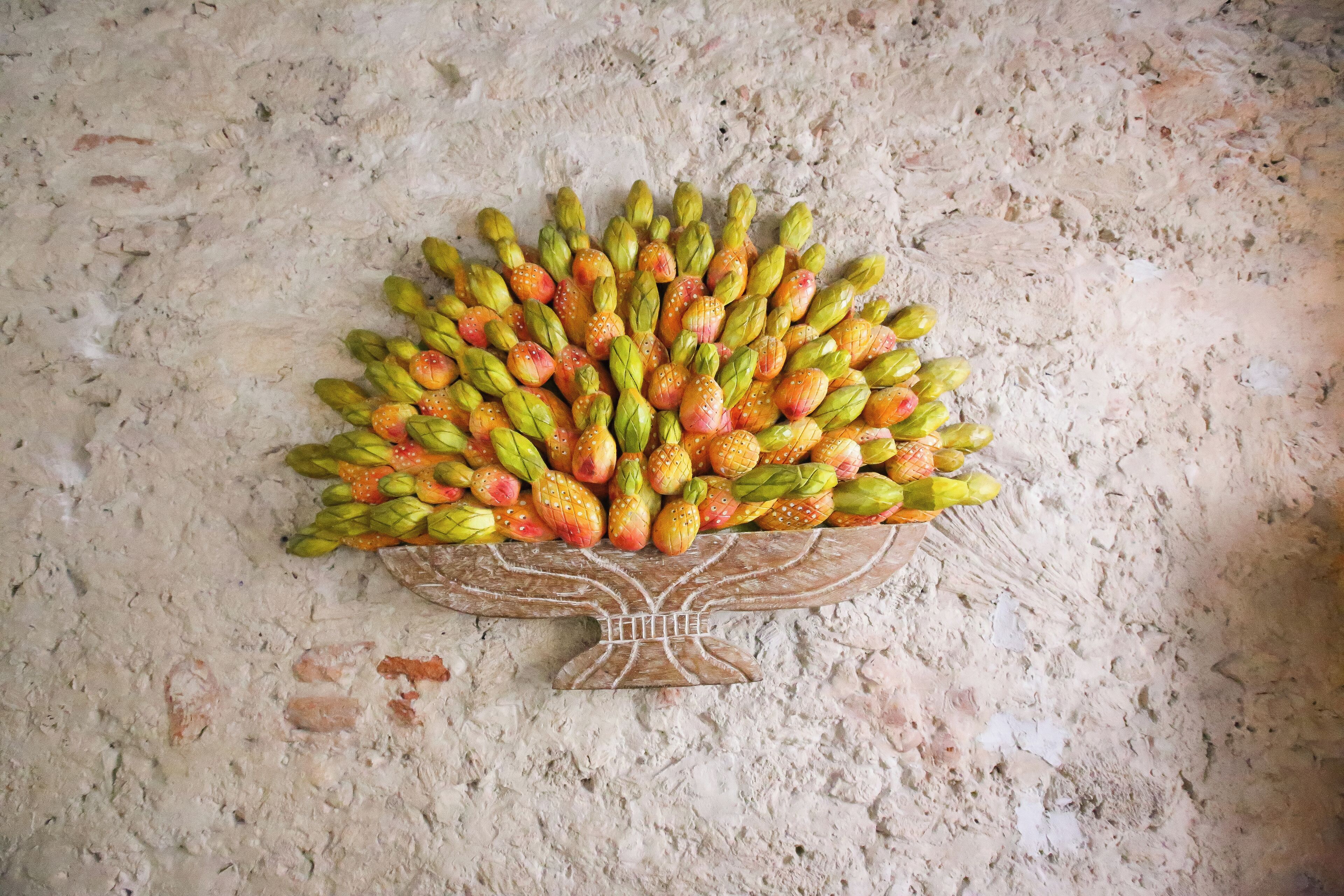 Un adorno de pared que representa un árbol con frutos.