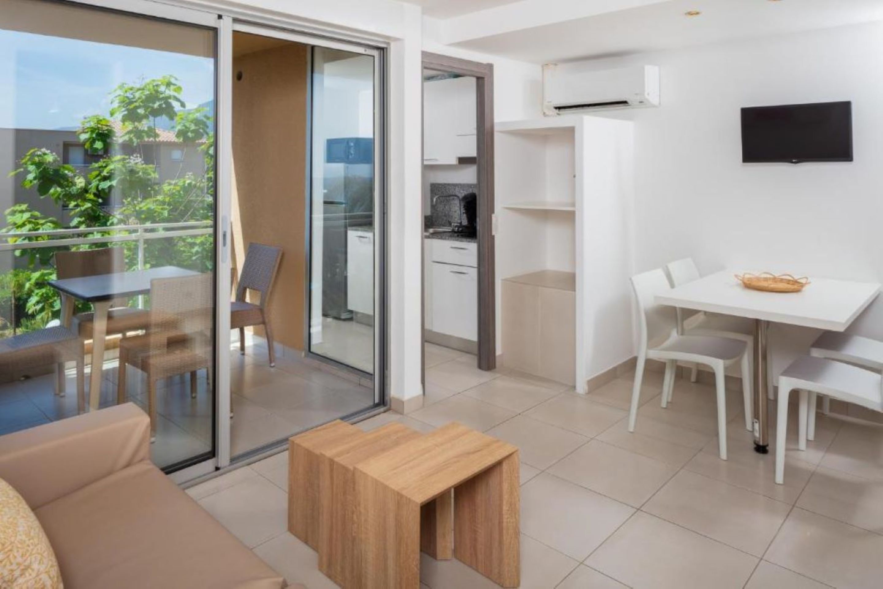 Un apartamento moderno con balcón, comedor y cocina.