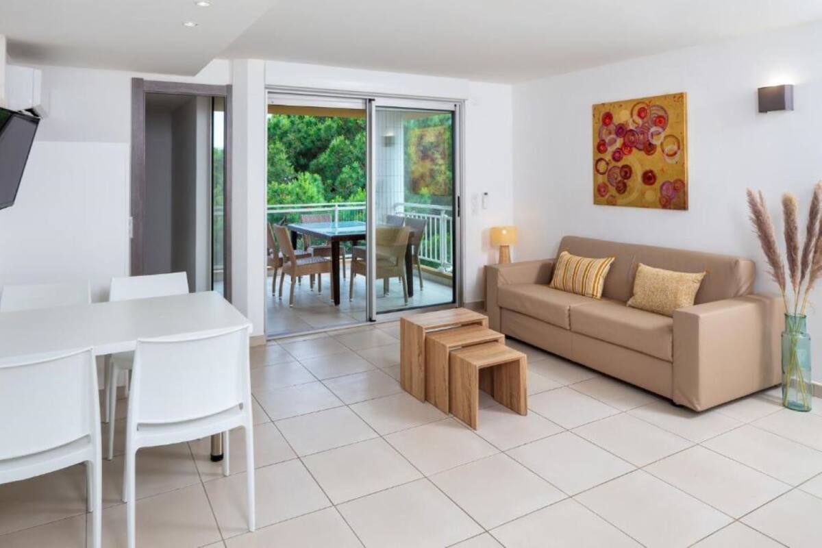 A modern living room with a sofa, coffee table, and dining area.