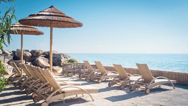 A beachside lounge area with sun loungers and thatched umbrellas, overlooking the sea. - Résidence Marina Bianca (Santa-Lucia-di-Moriani)