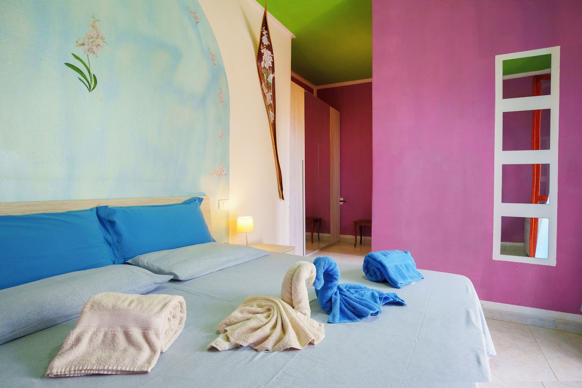 A hotel room with a bed, pillows, and towels.