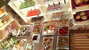 Un bufé con diversos alimentos, entre ellos frutas, verduras y pastelería.