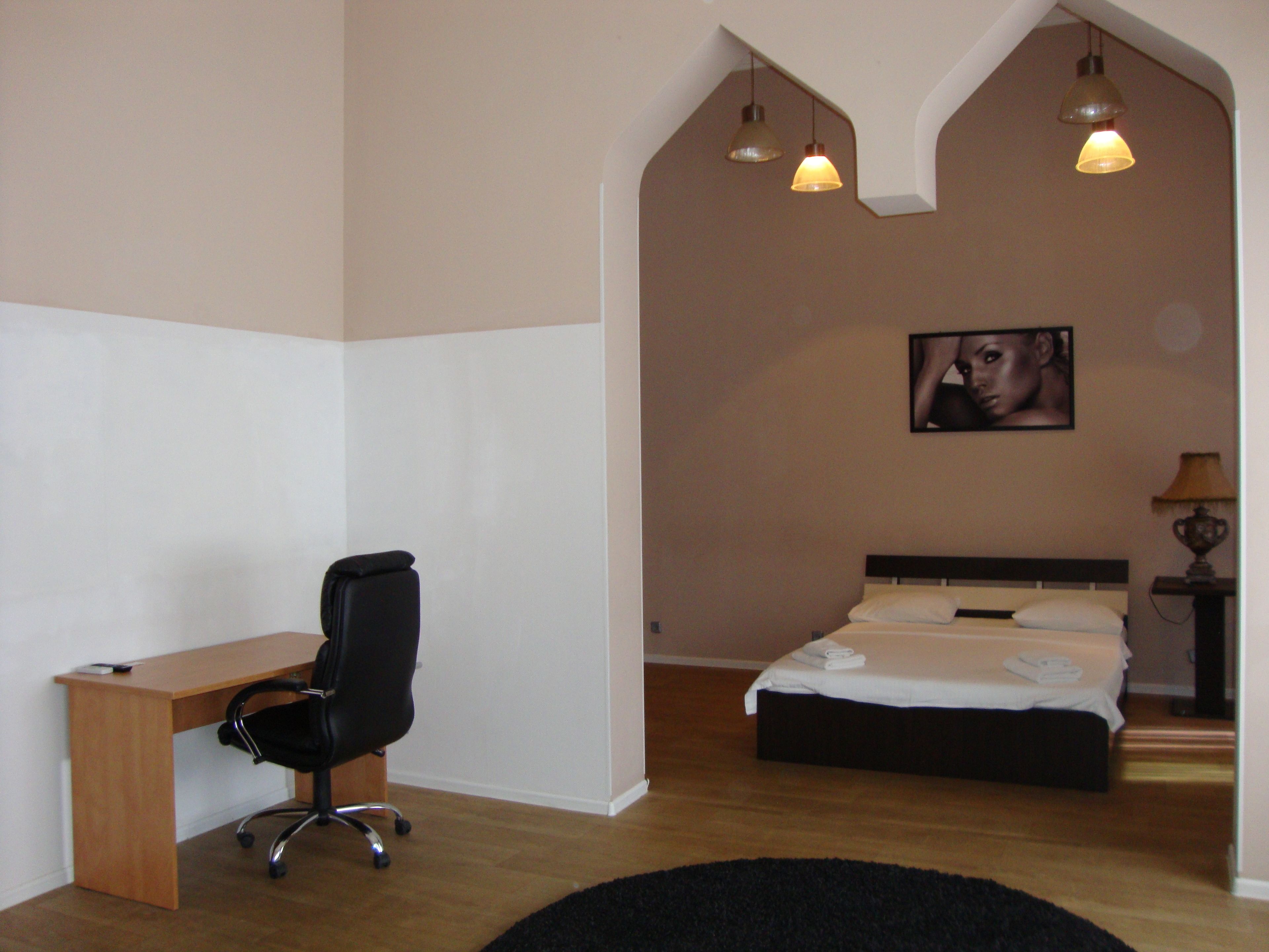 Un dormitorio con cama, escritorio y silla.