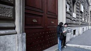 A large wooden door with a metal handle and a decorative panel. - La Maison de Marta (Rome)