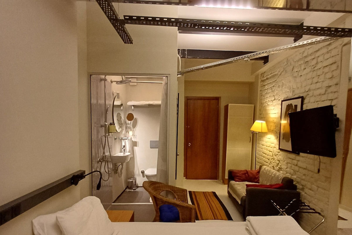 Een hotelkamer met een bed, badkamer, spiegel en televisie.