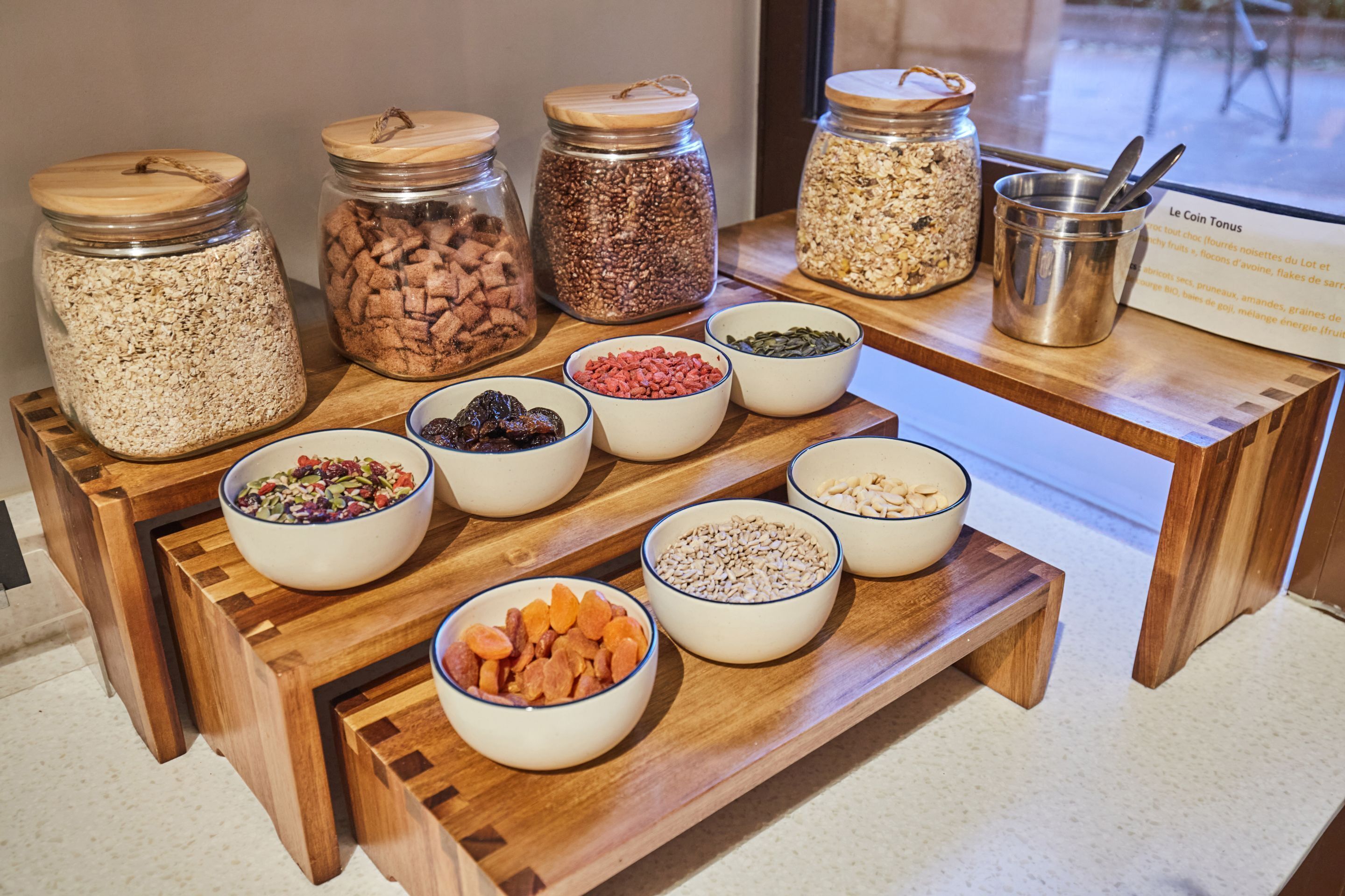 Een etalage met diverse potjes en schalen vol snacks en gedroogd fruit.