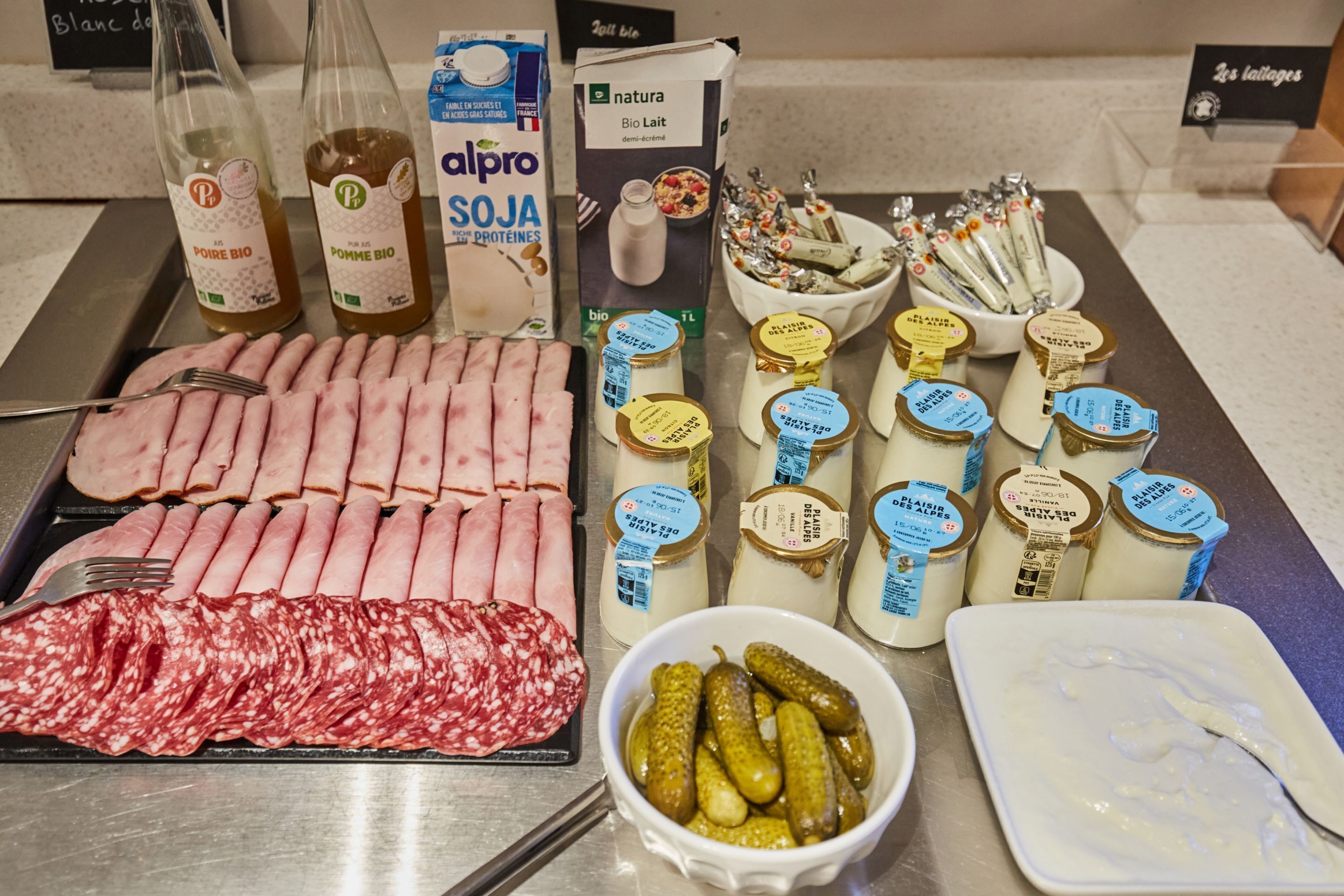 Ein reichhaltiges Buffet mit verschiedenen Speisen, darunter Aufschnitt, Käse und eingelegtes Gemüse.
