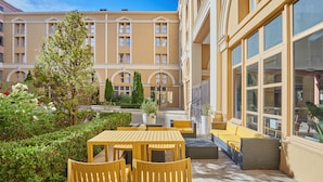 A courtyard with outdoor seating, a building with large windows, and a well-maintained garden. - Odalys City Apartment Hotel - Aix en Provence Centre Palais des Congrès (Aix-en-Provence)