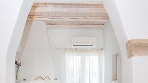 Una habitación acogedora con chimenea, una mesita y una silla.